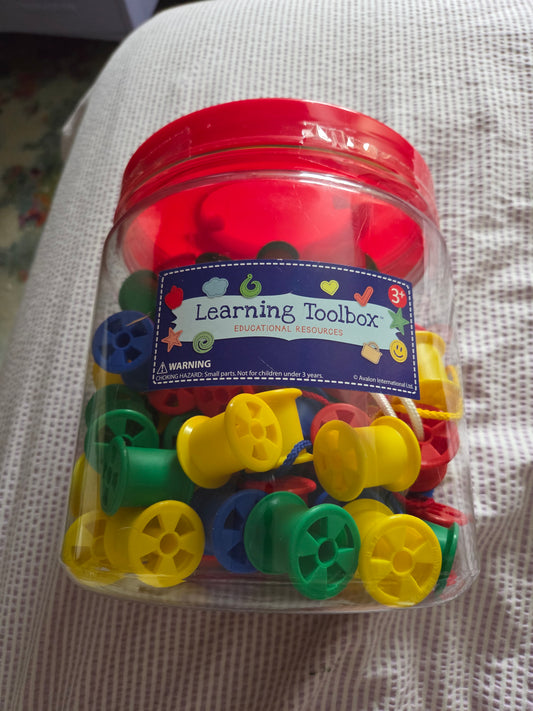 Large jar of threading cotton reels